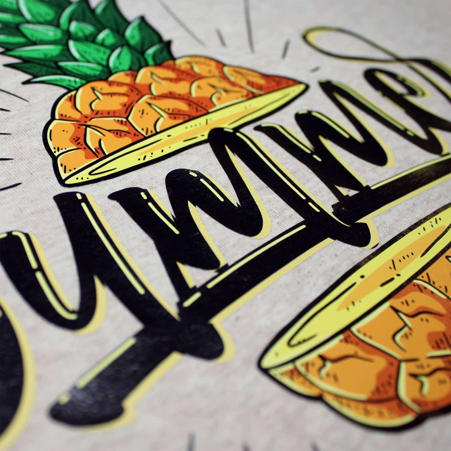 Nahaufnahme einer hochwertig bedruckten Textilie mit Ananas-Motiv und Schriftzug.